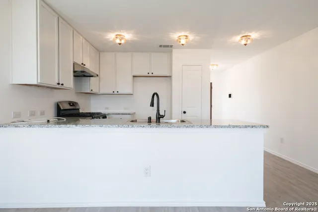 a kitchen with stainless steel appliances granite countertop a sink a stove and a refrigerator