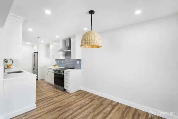 a kitchen with granite countertop a stove and a wooden floors
