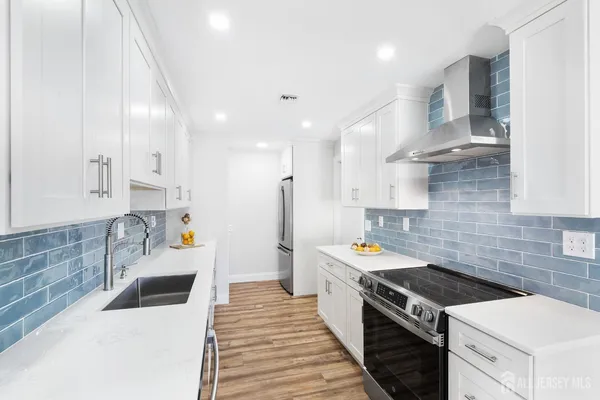 a kitchen with stainless steel appliances a stove a sink and a refrigerator