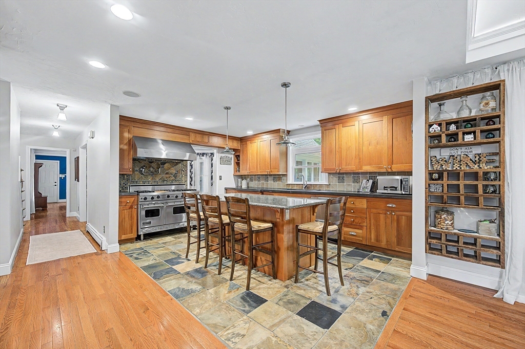 4 Dicarlo Road Hopkinton, MA 01748 - Photo 3 of 41 a dining hall with stainless steel appliances kitchen island granite countertop a table and chairs in it