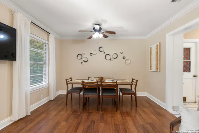a dining room with wooden floor a chandelier a glass table and chairs