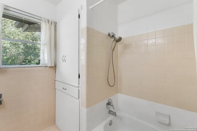 a bathroom with a bath tub with a shower