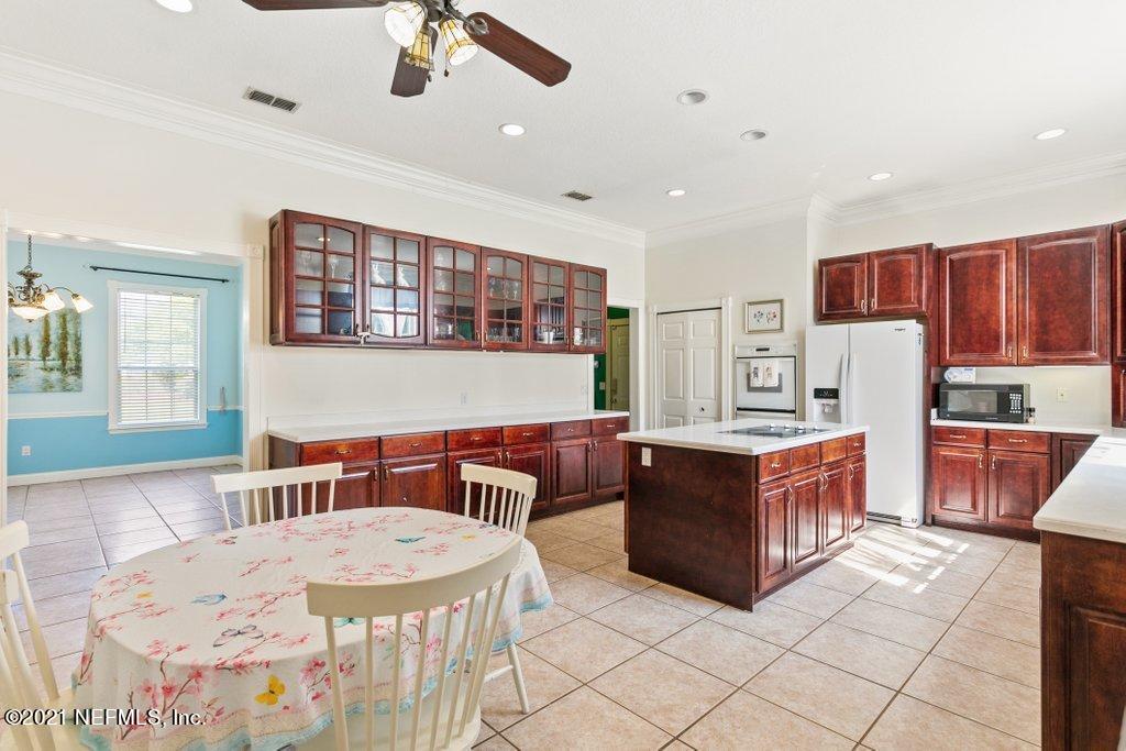 55268 Deer Run Road Callahan, FL 32011 - Photo 23 of 59 a kitchen with stainless steel appliances kitchen island granite countertop a sink and a refrigerator