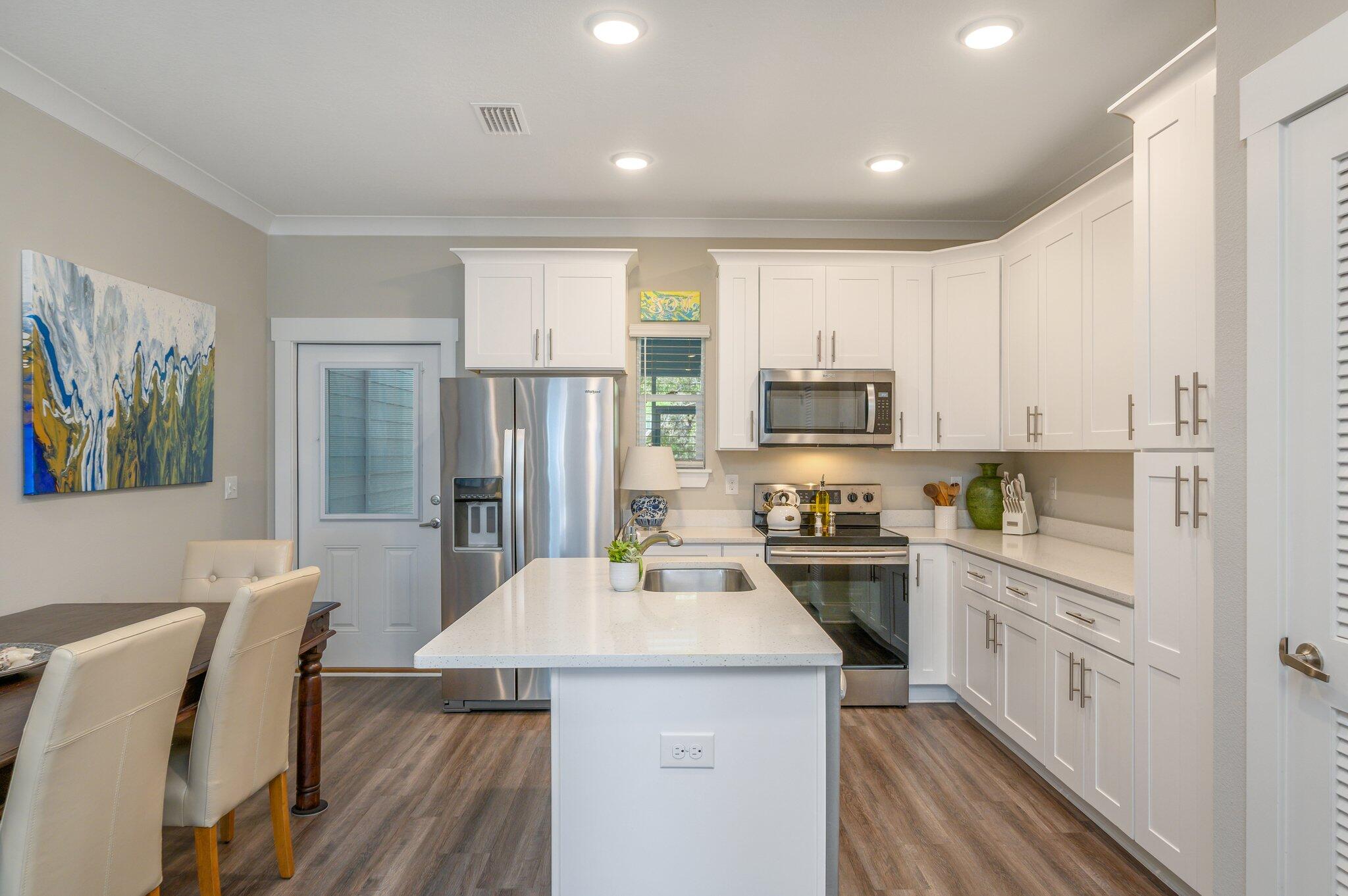 280 North Sand Palm Road Freeport, FL 32439 - Photo 8 of 34 a kitchen with a table chairs refrigerator and cabinets