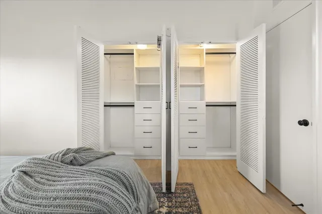 a bedroom with a bed and wooden floor