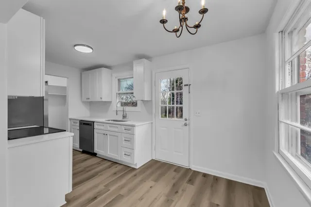 a kitchen with granite countertop a stove top oven a sink dishwasher and a refrigerator with wooden floor