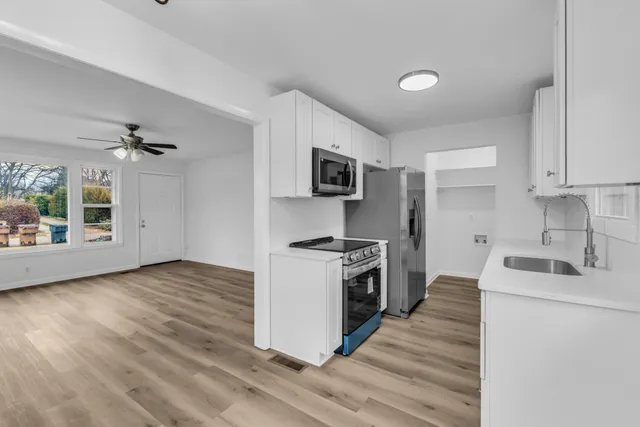 a kitchen with stainless steel appliances granite countertop a sink and a stove top oven