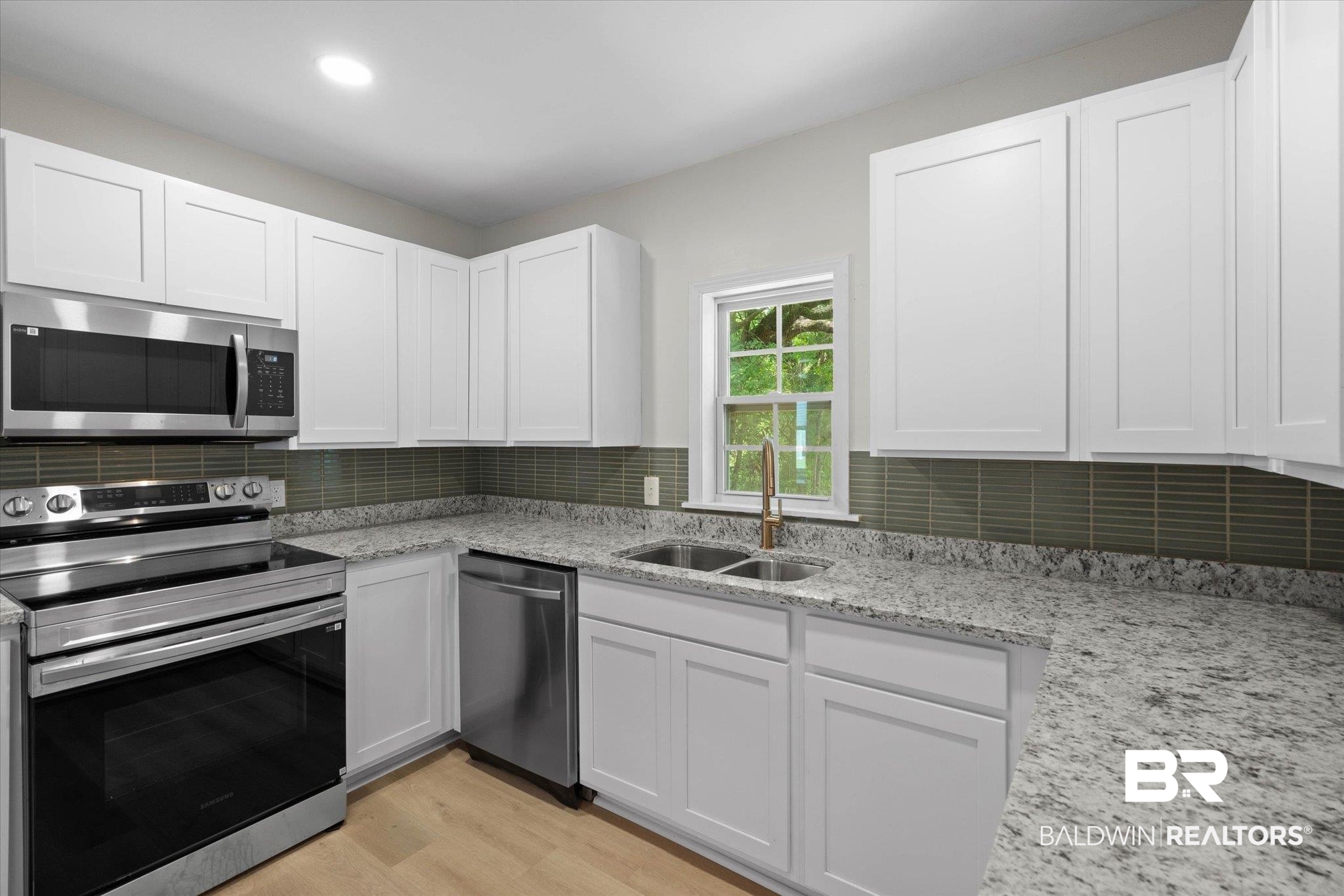 3512 Spring Hill Avenue Mobile, AL 36608 - Photo 6 of 20 Kitchen featuring appliances with stainless steel finishes, white cabinetry, and tasteful backsplash
