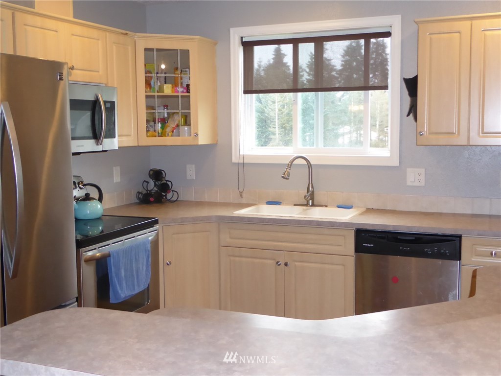 9024 176th Avenue Southwest Rochester, WA 98579 - Photo 5 of 25 a kitchen with stainless steel appliances granite countertop a sink stove and refrigerator