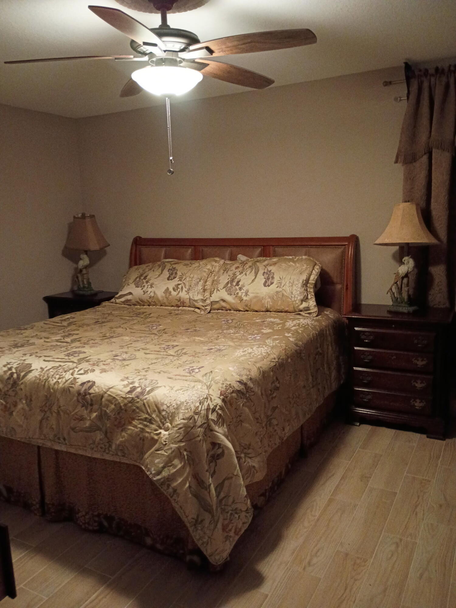 116 Southwest Ridgecrest Drive, Unit A Port St. Lucie, FL 34953 - Photo 2 of 8 a bed sitting in a bedroom next to a lamp