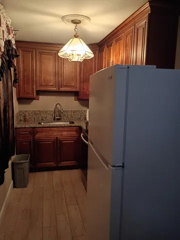 a kitchen with stainless steel appliances kitchen island granite countertop a refrigerator a sink and dishwasher