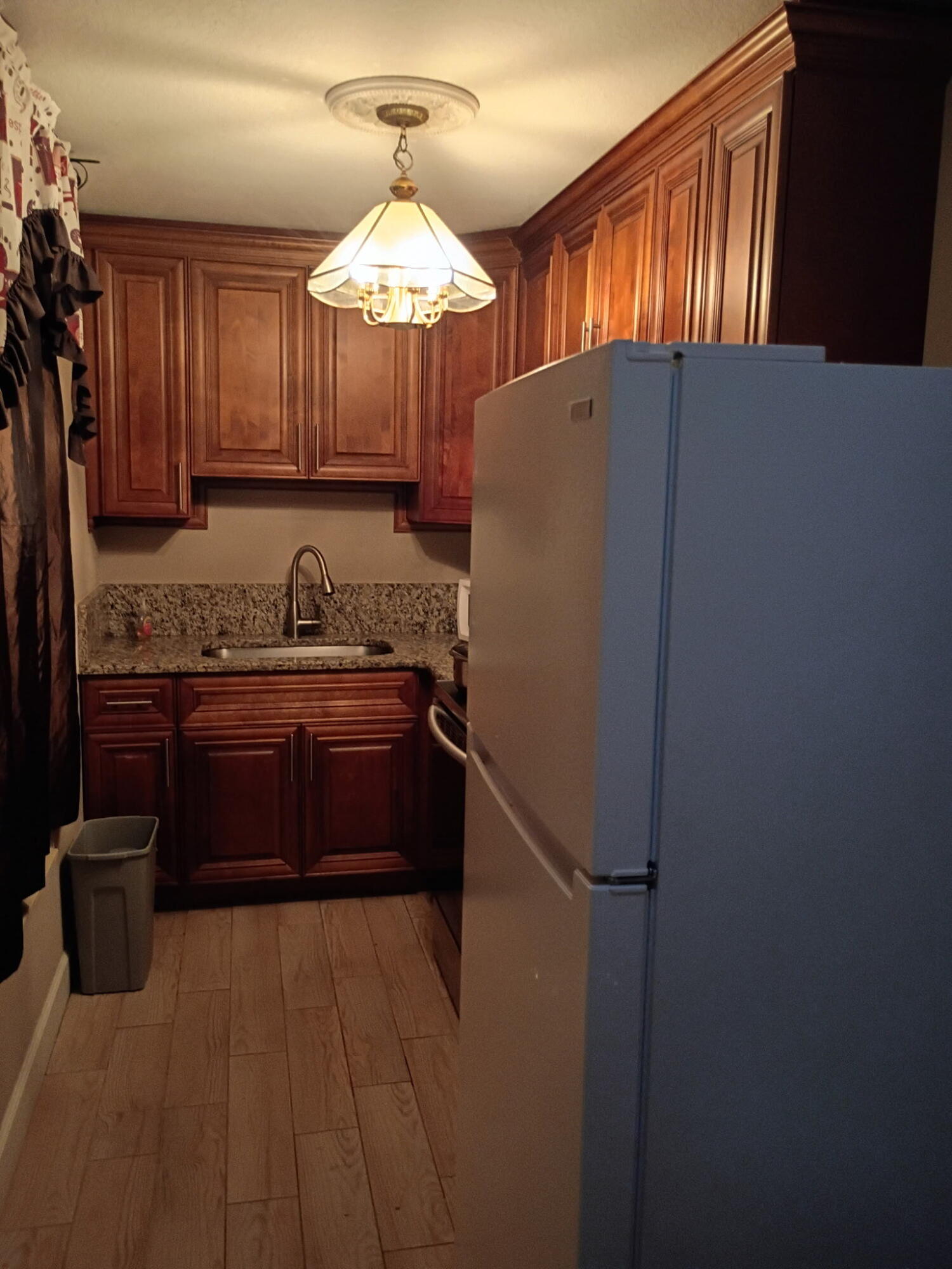 116 Southwest Ridgecrest Drive, Unit A Port St. Lucie, FL 34953 - Photo 8 of 8 a kitchen with stainless steel appliances kitchen island granite countertop a refrigerator a sink and dishwasher