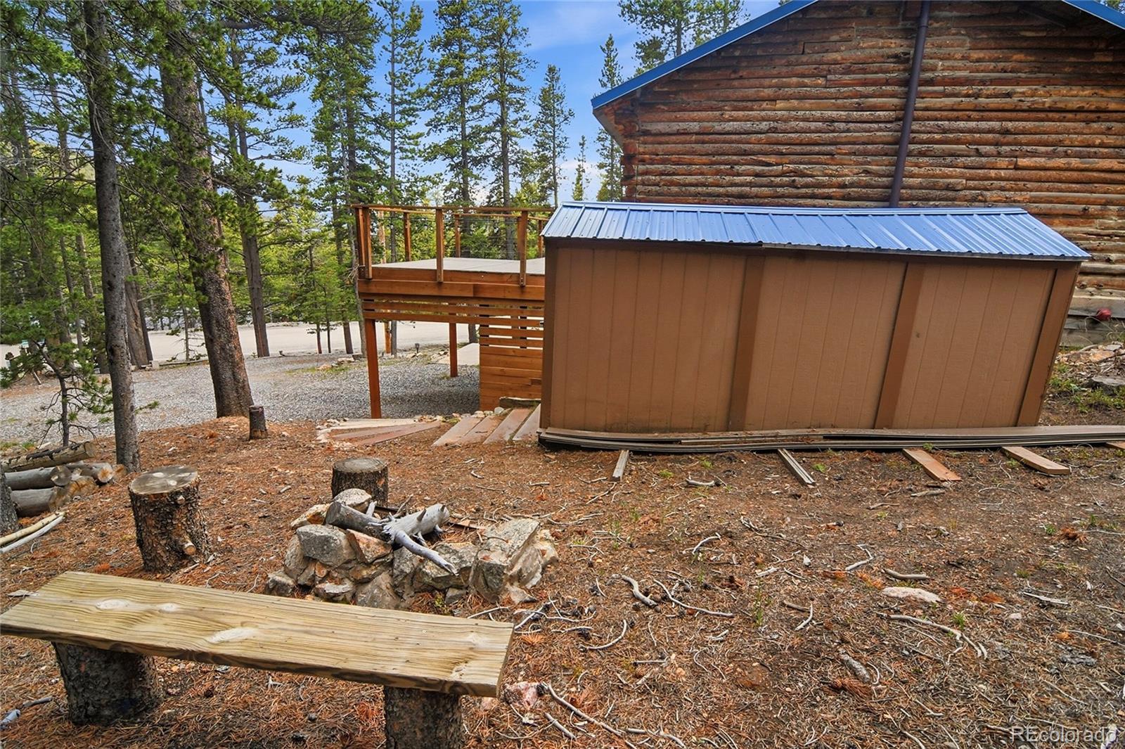 185 Alice Road Idaho Springs, CO 80452 - Photo 28 of 43 a backyard of a house with large trees and wooden fence