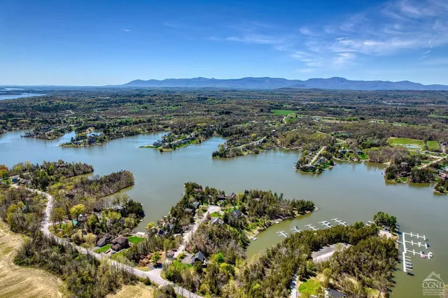 an aerial view of ocean and residential houses with outdoor space