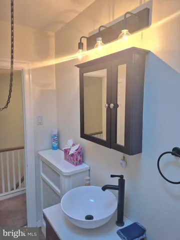 an empty room with wooden floor and fan