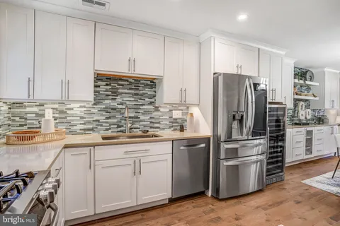 a kitchen with kitchen island a counter top space cabinets and stainless steel appliances