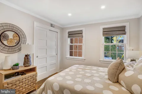 a bedroom with a bed and a lamp on the dresser