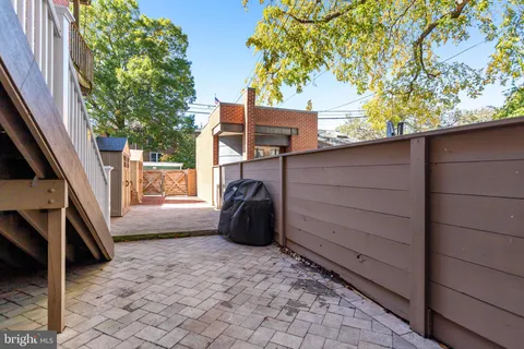 a front view of a house with stairs and wooden fence