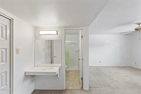 a bathroom with a granite countertop sink toilet a mirror and shower