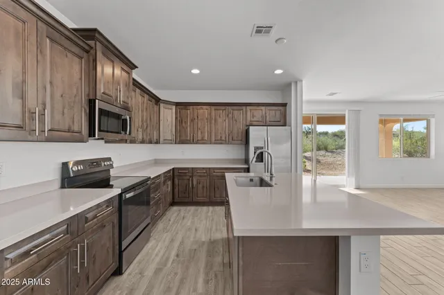 a kitchen with stainless steel appliances granite countertop a sink stove microwave and cabinets