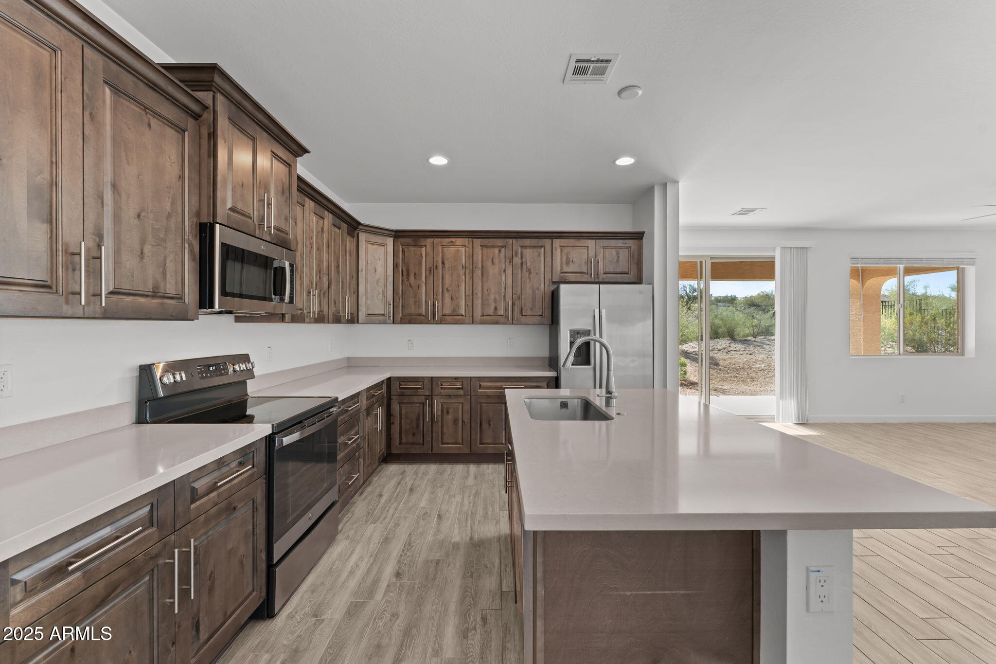 a kitchen with stainless steel appliances granite countertop a sink stove microwave and cabinets