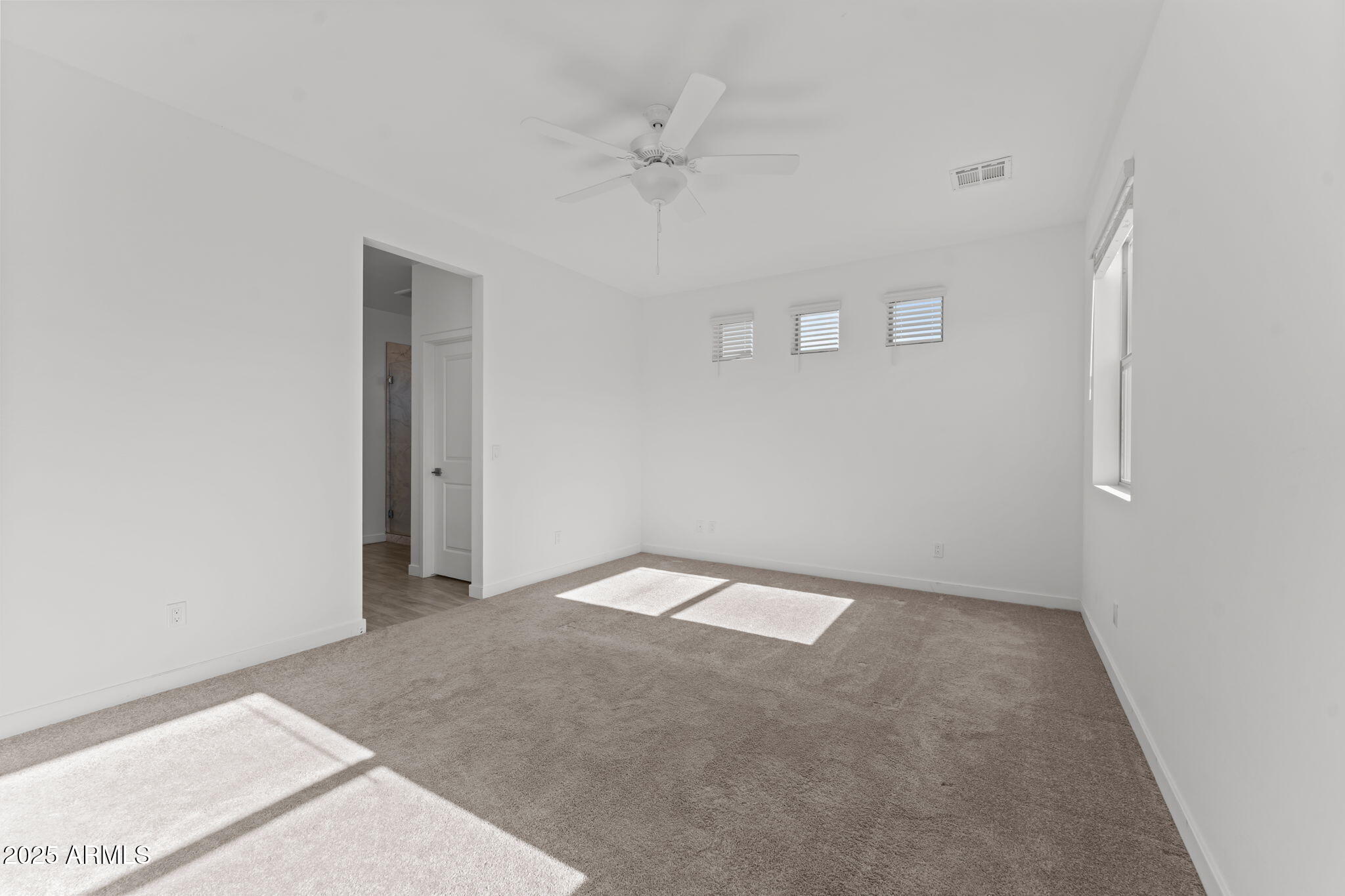 1985 West Ringo Road Wickenburg, AZ 85390 - Photo 15 of 25 an empty room with a ceiling fan and a window