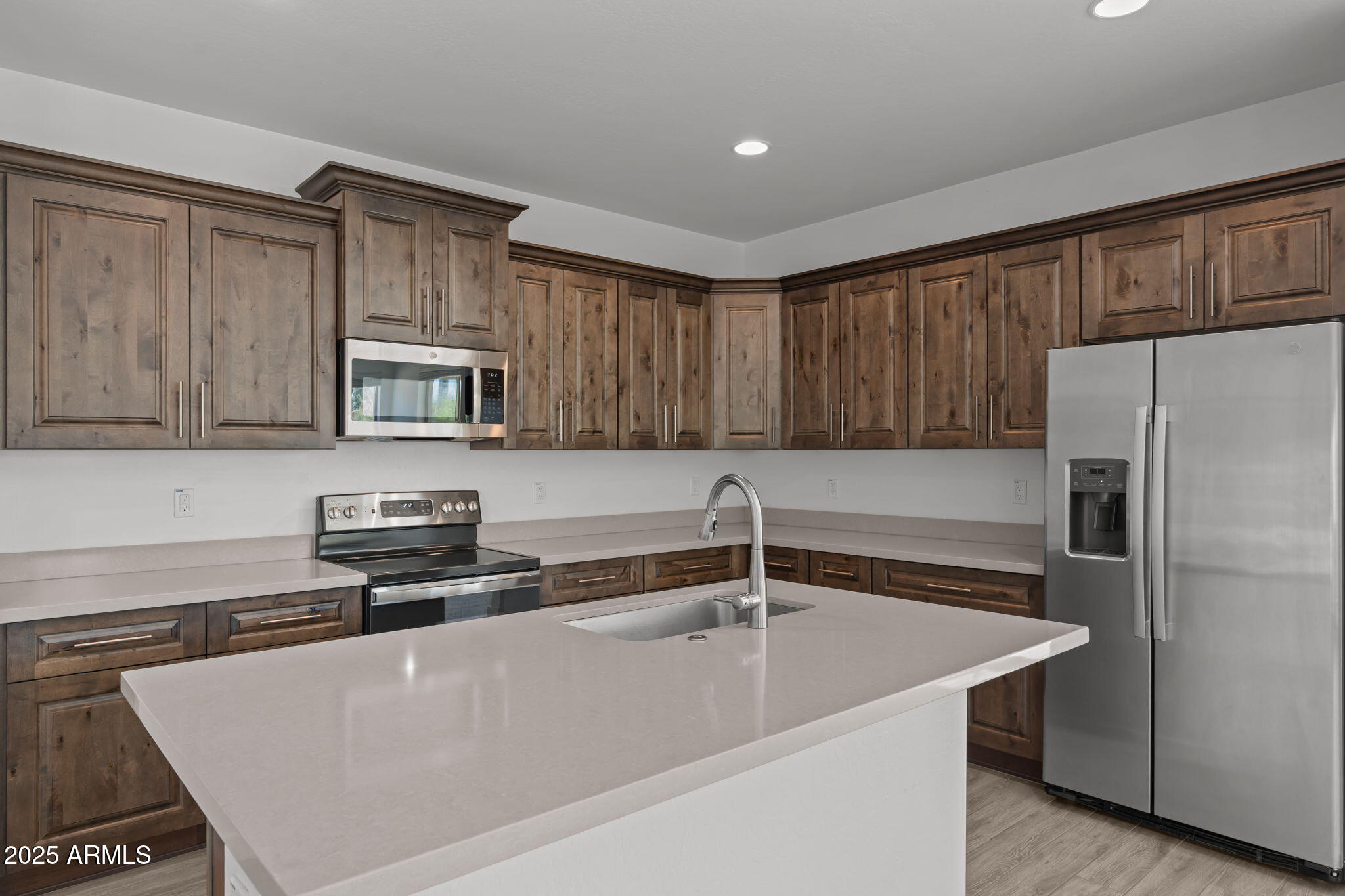 1985 West Ringo Road Wickenburg, AZ 85390 - Photo 4 of 25 a kitchen with stainless steel appliances a refrigerator a sink a stove a microwave and wooden cabinets