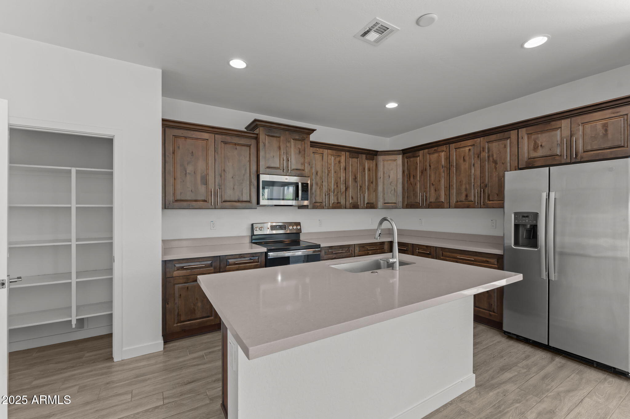 1985 West Ringo Road Wickenburg, AZ 85390 - Photo 5 of 25 a kitchen with kitchen island a sink stainless steel appliances and cabinets