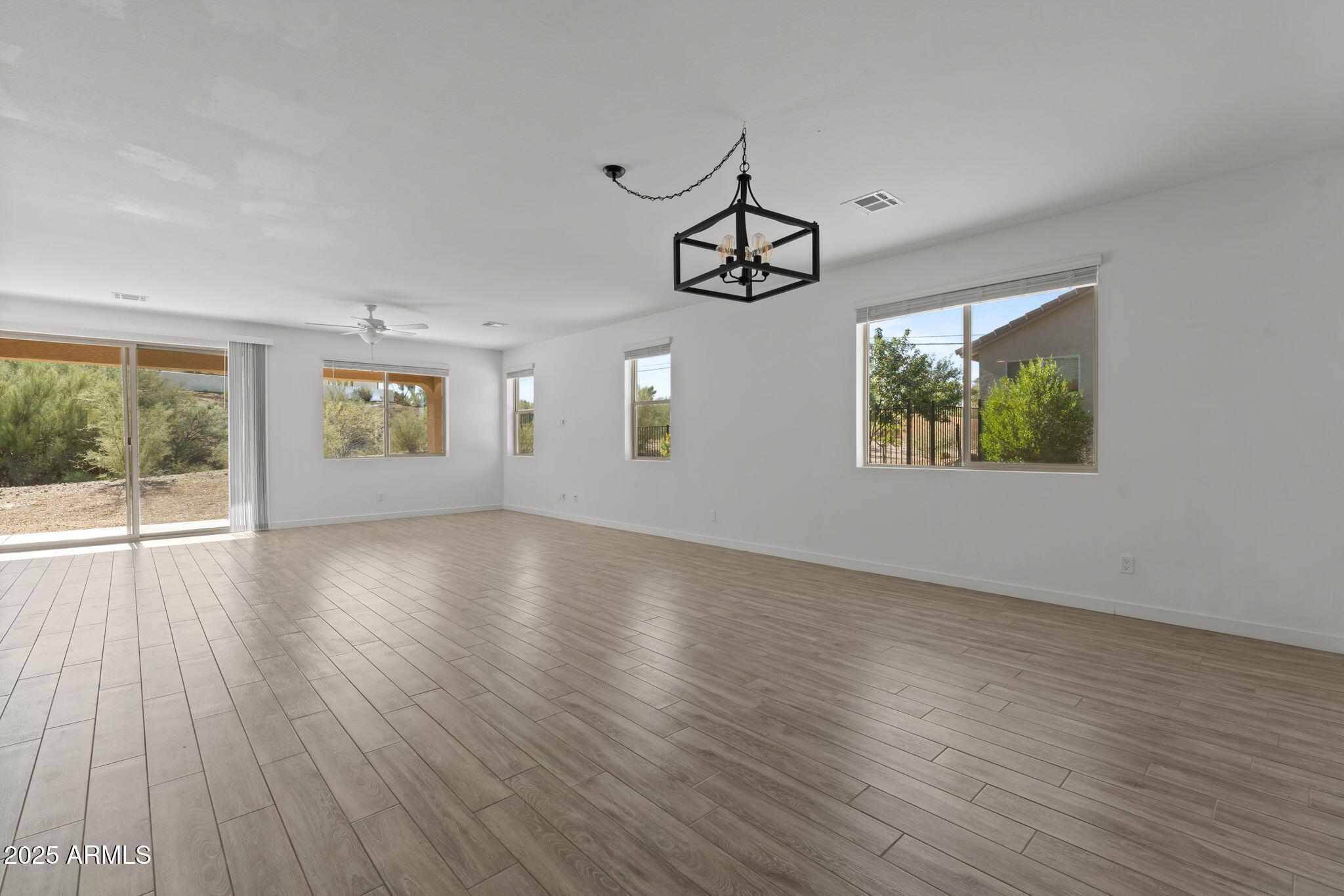 1985 West Ringo Road Wickenburg, AZ 85390 - Photo 7 of 25 a view of an empty room with wooden floor and window
