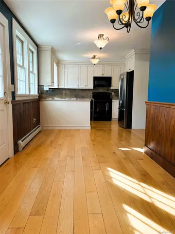 a view of empty room with wooden floor and fireplace