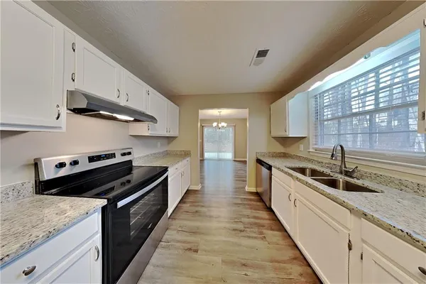 a large kitchen with stainless steel appliances granite countertop a lot of counter space