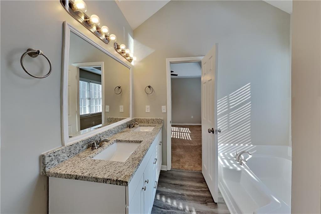 2705 Braemore Place Powder Springs, GA 30127 - Photo 7 of 18 a bathroom with a granite countertop sink and a mirror