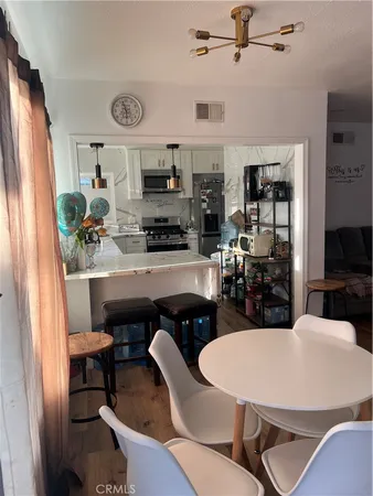 a kitchen with stainless steel appliances kitchen island granite countertop a refrigerator a stove a microwave oven with a dining table and chairs
