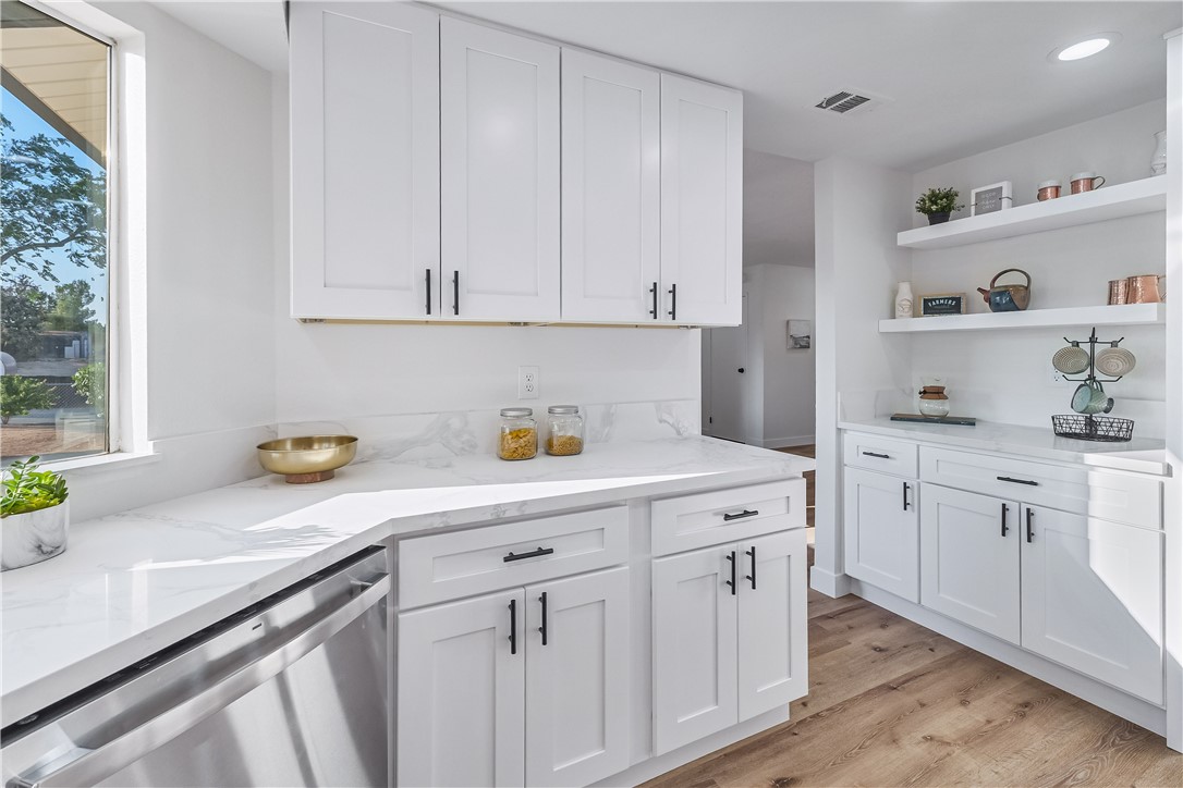7046 Seventh Avenue Hesperia, CA 92345 - Photo 19 of 46 a kitchen with white cabinets and a window
