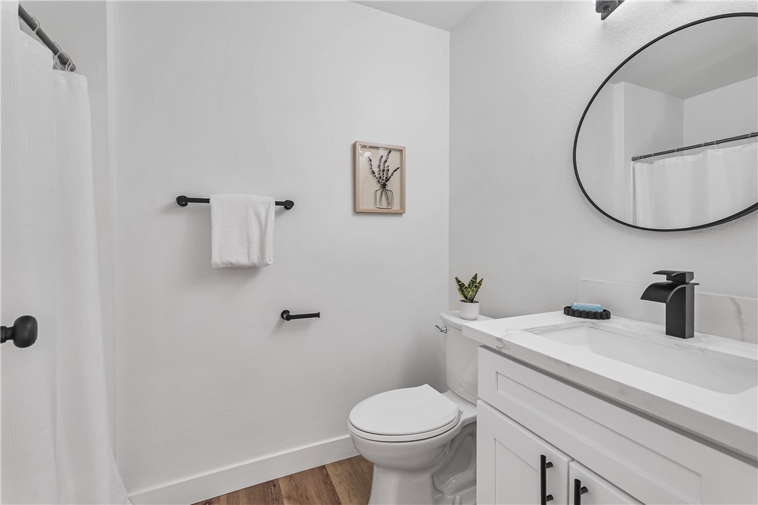 7046 Seventh Avenue Hesperia, CA 92345 - Photo 23 of 46 a bathroom with a toilet a sink and mirror