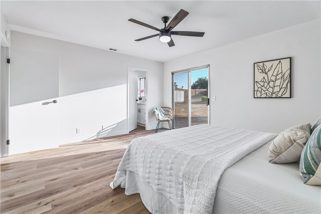 7046 Seventh Avenue Hesperia, CA 92345 - Photo 27 of 46 a bedroom with bed and wooden floor