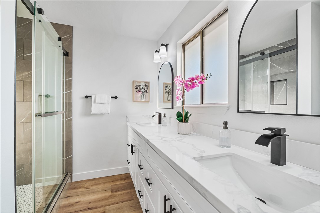 7046 Seventh Avenue Hesperia, CA 92345 - Photo 29 of 46 a bathroom with a granite countertop sink mirror and vanity