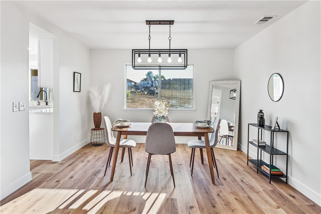 7046 Seventh Avenue Hesperia, CA 92345 - Photo 6 of 46 a view of a dining room with furniture window and wooden floor