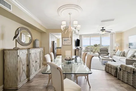 a view of a dining room with furniture a chandelier and wooden floor