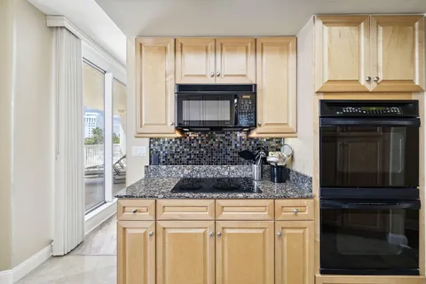 a kitchen with granite countertop a stove sink and cabinets