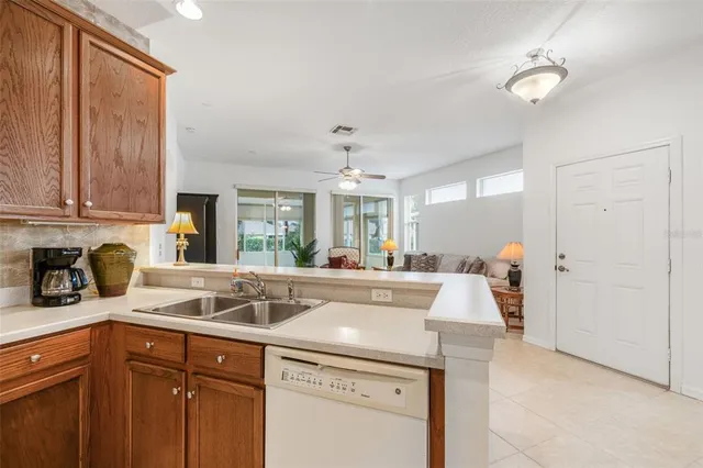 a kitchen with a sink dishwasher a stove and white cabinets with wooden floor