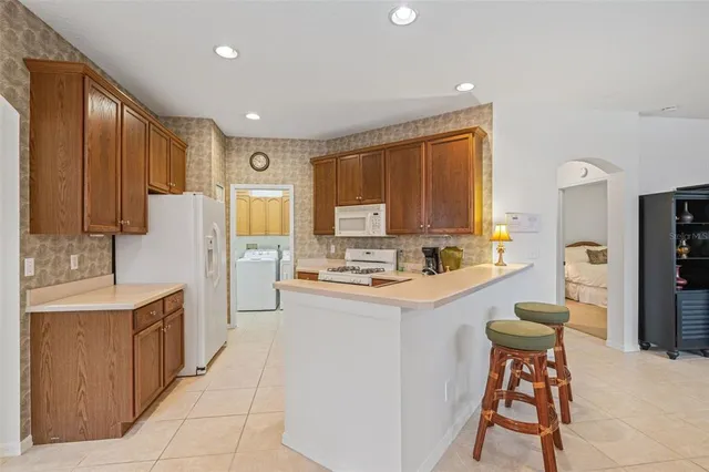 a kitchen with stainless steel appliances kitchen island granite countertop a refrigerator and a stove top oven