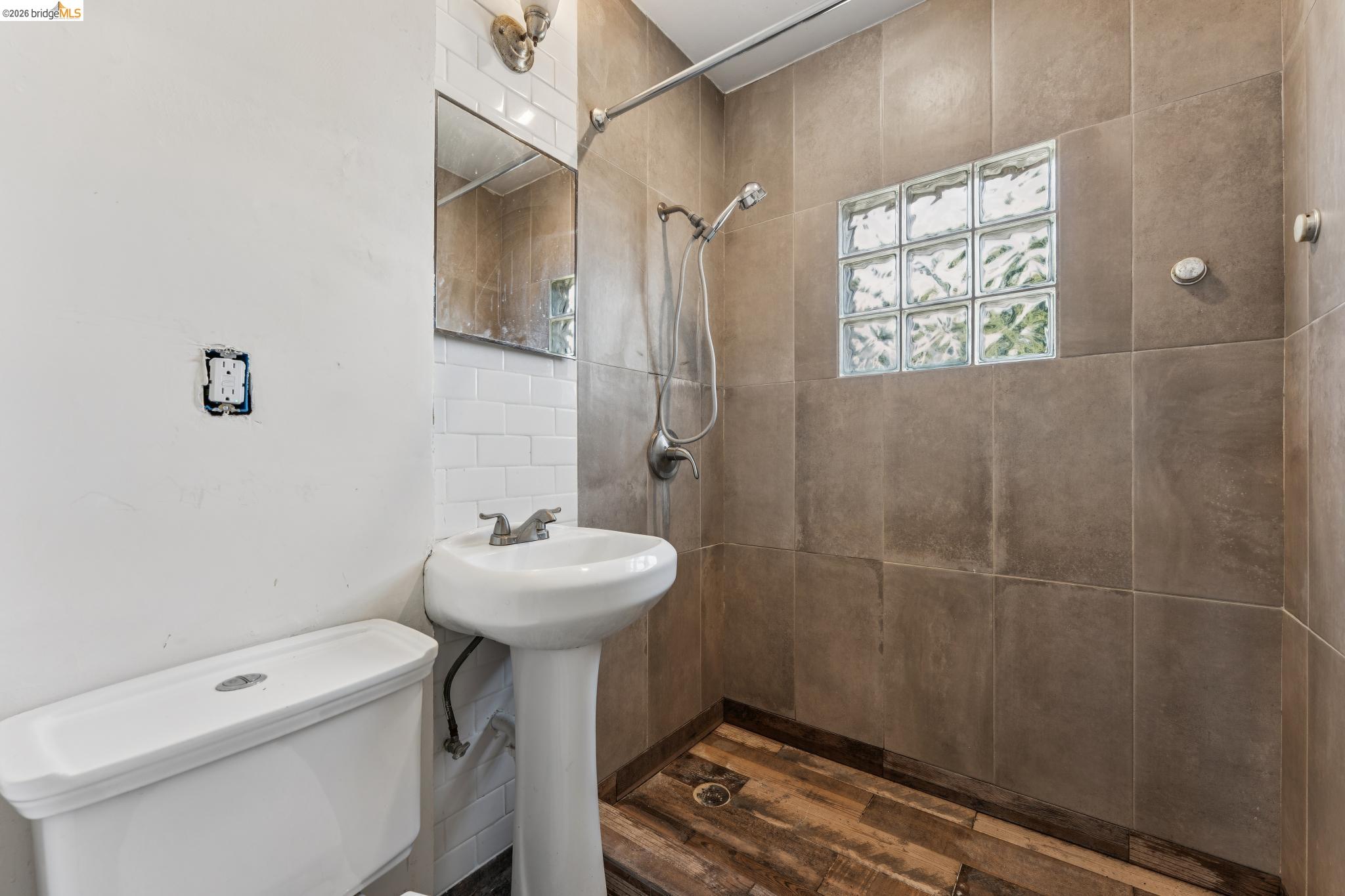 2879 Rheem Avenue Richmond, CA 94804 - Photo 31 of 45 Bathroom featuring a pedestal sink, white subway tile backsplash, and a shower with glass block accents