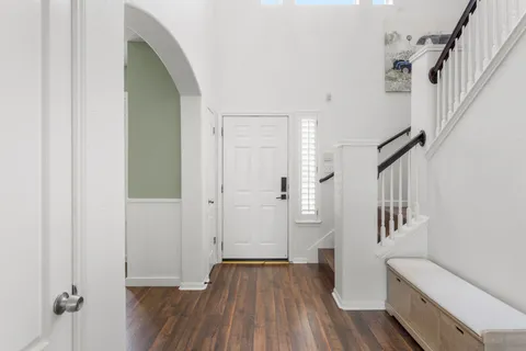 a view of a hallway with wooden floor and staircase
