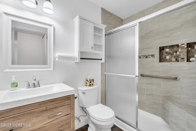 a bathroom with a sink a toilet and shower