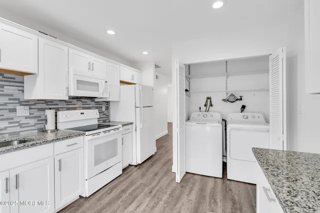 a kitchen with white cabinets and white appliances