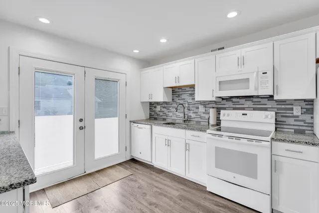 a kitchen with white cabinets and white appliances
