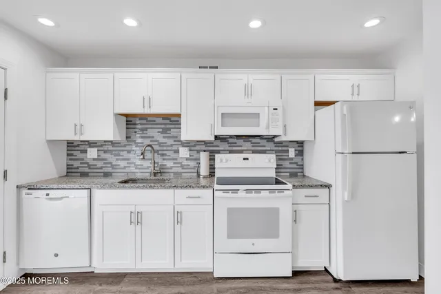 a kitchen with white cabinets and white appliances