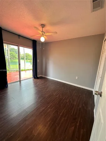 an empty room with wooden floor and entrance