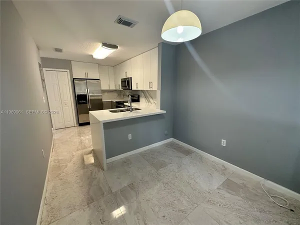 a kitchen with a sink a counter top space cabinets and stainless steel appliances
